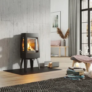 Dovre Sense 103 vedovn – moderne sort ovn med flammer i lys stue med rosa stol og bøker hos Peisbutikken.no