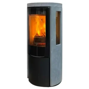 En Jydepejsen Cozy Modern Klebrestein Sideglass peisovn mot en hvit bakgrunn, med en slank sort base og en teksturert grå kleberstein kropp med to sideglasspaneler som avslører det glødende vedfryt som brenner inni. Peisovnens sylindriske form og panoramiske forreste glassdør forsterker dens moderne estetikk, med flammene som kaster et varmt lys som fremhever dens robuste konstruksjon og elegante design.