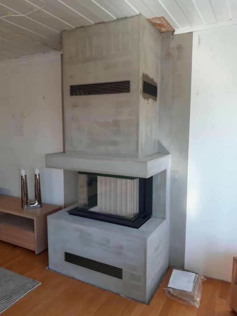 Spartherm peisinnsats montert av Peisbutikken i Enebakk – moderne panoramainnsats med betongomramming i moderne stue hos Peisbutikken.no